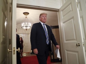 In this March 23, 2018, photo, President Donald Trump walks into the Diplomatic Room of the White House in Washington.