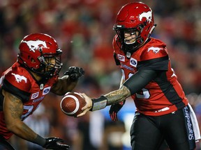 Calgary Stampeders quarterback Bo Levi Mitchell, right, hands the ball off to running back Terry Williams (38) during second half CFL football action against the Montreal Alouettes in Calgary, Friday, Sept. 29, 2017. THE CANADIAN PRESS/Jeff McIntosh