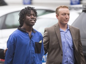 Lloyd Kollie, 19, accused in the murder of Maqsood Ahmed is brought to the Calgary Police processing unit in Calgary on Wednesday, June 17, 2015. (Aryn Toombs)