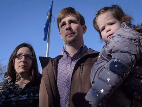 Edouard Maurice, centre, speaks to reporters outside court while holding his daughter Teal as his wife, Jessica, looks on in Okotoks, Alta., on March 9, 2018.
