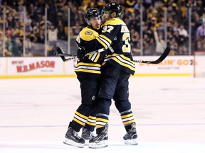 Brad Marchand of the Boston Bruins celebrates with Patrice Bergeron after scoring against the Toronto Maple Leafs during an NHL playoff game at TD Garden on April 12, 2018
