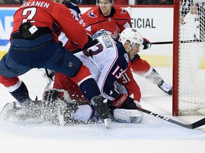 Blue Jackets right wing Cam Atkinson (13) collides into Capitals goaltender Philipp Grubauer during Game 2 of their NHL playoff series in Washington, Sunday, April 15, 2018. (AP Photo/Nick Wass)
