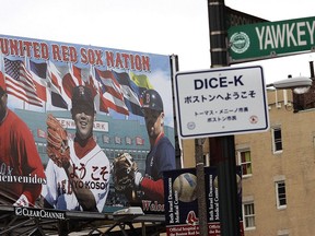 In this April 10, 2007 file photo, a Yawkey Way street sign hangs on a pole outside Fenway Park before a game between the Boston Red Sox and Seattle Mariners in Boston.