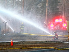 Calgary firefighters soak down terrain along 37th Street S.W. in Lakeview after a large grass fire on Saturday, April 28, 2018.