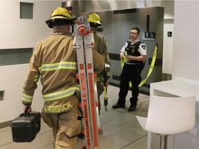 Firefighters enter a washroom in Calgary's CORE mall food court after reports that a body had been found in the wall of the washroom on Monday, April 30, 2018.