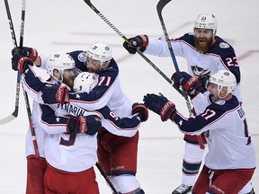 Columbus Blue Jackets left wing Artemi Panarin (9) celebrates his game-winning goal in overtime with Nick Foligno (71), Brandon Dubinsky (17), Ian Cole (23) and David Savard (58) in Game 1 against the Washington Capitals, Thursday, April 12, 2018, in Washington. (AP Photo/Nick Wass)