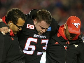 Calgary Stampeders Pierre Lavertu is helped off the field during their game against Toronto Argonauts in CFL action at McMahon Stadium in Calgary, Alta.. on Friday October 21, 2016. Leah hennel/Postmedia