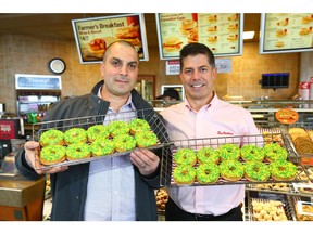 Alex Halat, local philanthropist and from the Chestermere/ Langdon Oilmen's Assoc (L) and Andrew Marriott, Chestermere Tim Horton's owner/ franchisee pose in Chestermere, east of Calgary on Friday, April 13, 2018. The pair are displaying specially decorated donuts and funds will go to the Humboldt fundraising effort. Jim Wells/Postmedia
