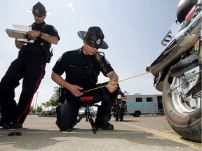 Edmonton, AB. June 19, 2010: Cst Michael Fehr (centre) tests the sound level of an a motorcycle during a voluntary decible check event near Calgary trail and University Avenue, Saturday. Another event will be held at the location Sunday form 10 a.m. to 6 p.m. for motorcycle owners who want to check the decible level of their vehicle. The police were not handing out tickets at the event. Several hundred motorcycles were checked at the event. MORE BACKGROUND--Members of the Edmonton Police Service Traffic Section will soon start conducting testing on motorcycles that appear to exceed industry-approved noise levels. Last week city council approved a bylaw amendment on excessive vehicle noise. Under the bylaw, a $250 fine can be issued for motorcycles that exceed 92 decibels while idling or 96 decibels when the engine speed is at higher rpms. DAVID BLOOM/ EDMONTON SUN QMI AGENCY