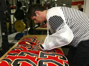 Calgary Flames Sean Monahan signs jerseys during garbage bag day at the Scotiabank Saddledome on Monday, April 9, 2018.