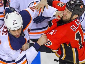 Edmonton Oilers big-guy Milan Lucic fights Tanner Glass of the Calgary Flames during NHL hockey at the Scotiabank Saddledome in Calgary on Saturday, March 31, 2018.