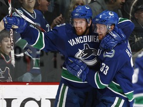 VANCOUVER, CANADA - DECEMBER 27:   Daniel Sedin #22 and Henrik Sedin ## of the Vancouver Canucks celebrates a Vancouver goal against the Calgary Flames during their game at General Motors Place on December 27, 2007 in Vancouver, British Columbia, Canada.  (Photo by Jeff Vinnick/NHLI via Getty Images)