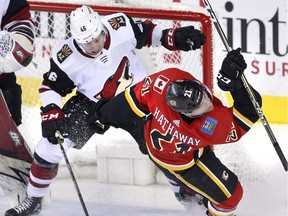 Calgary Flames' Garnet Hathaway (right) is knocked down by Arizona Coyotes' Trevor Murphy in front of the Arizona net during second period NHL action in Calgary, Alta., Tuesday, April 3, 2018.