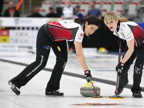 Jill Officer (L) and Dawn McEwen sweep a shot at the Pinty's Grand Slam of Curling Humpty's Champions Cup event at WInSport in Calgary