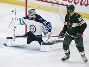 ST PAUL, MN - APRIL 17: Connor Hellebuyck #37 of the Winnipeg Jets makes a stick save as Matt Dumba #24 of the Minnesota Wild looks on during the third period in Game Four of the Western Conference First Round during the 2018 NHL Stanley Cup Playoffs at Xcel Energy Center on April 17, 2018 in St Paul, Minnesota. The Jets defeated the Wild 2-0. (Photo by Hannah Foslien/Getty Images)