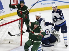 Wild left wing Marcus Foligno (17) and Wild centre Joel Eriksson Ek (14) celebrate after Foligno scored a goal on Jets goalie Connor Hellebuyck and Jets' Ben Chiarot (7) and Jacob Trouba (8) during Game 3 of their NHL playoff series in St. Paul, Minn., Sunday, April 15, 2018. (Andy Clayton-King/AP Photo)