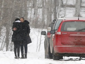 A family member is hugged as RCMP investigate a home in Morley where an infant died and 10 children were taken to hospital on Wednesday April 4, 2018.