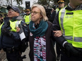 Federal Green Party Leader Elizabeth May, centre, is arrested by RCMP officers after joining protesters outside Kinder Morgan's facility in Burnaby, B.C., on Friday March 23, 2018.