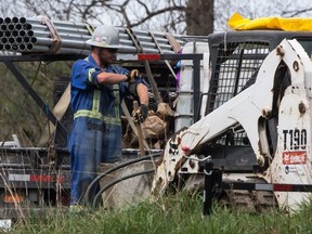 A worker rolls up his sleeves as work continues at Kinder Morgan's facility in preparation for the expansion of the Trans Mountain Pipeline, in Burnaby, B.C., on Monday April 9, 2018.