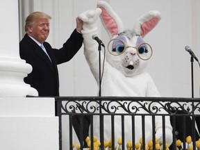 President Donald Trump and the Easter Bunny, after speaking to the crowd on the Truman Balcony during the annual White House Easter Egg Roll on the South Lawn of the White House in Washington, Monday, April 2, 2018.