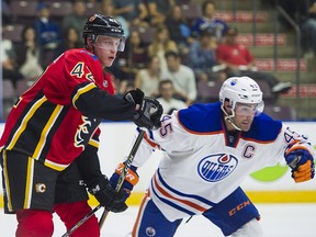 Flames prospect Juuso Valimaki checks the Edmonton Oilers' Joe Gambardella during an NHL Young Stars Classic game in Penticton, B.C., on Sept. 8, 2017.