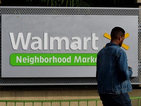 This file photo taken on January 16, 2016 shows a manwalking past a Walmart store in Chinatown, Los Angeles. (MARK RALSTON/AFP/Getty Images)