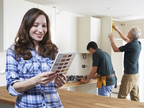 Woman Looking At Paint Chart In New Kitchen