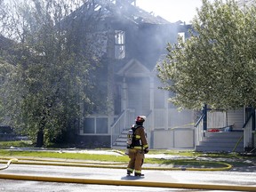 Firefighters at the scene of a house fire in the 400 block of Country hills Drive NW in Calgary, on Saturday May 19, 2018. Leah Hennel/Postmedia
