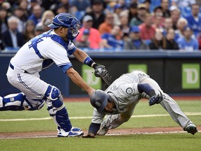 Toronto Blue Jays catcher Luke Maile tags out Seattle Mariners shortstop Jean Segura on a run down in Toronto on Wednesday May 9, 2018. (THE CANADIAN PRESS/Nathan Denette)