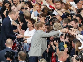 Britain's Prince William, top left, and Prince Harry, center, greet crowds in Windsor, near London, England, Friday, May 18, 2018. Preparations continue in Windsor ahead of the royal wedding of Britain's Prince Harry and Meghan Markle on Saturday May 19.