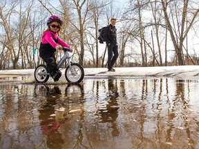 Isabella, 3, geared up with snow pants and rubber boots to have fun run-biking through puddles while her dad watched on St. George's Island, Saturday April 14, 2018. Spring weather is set to continue Sunday before more snow on Monday. Gavin Young/Postmedia