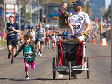 Peter Emes holds his son as he runs with daughter Tori towards the 5 km finish line in the Sport Chek Mother's Day Run Walk and Ride at Chinook Centre on Sunday May 13, 2018. The event is a fundraiser for the neonatal intensive care units in Calgary.