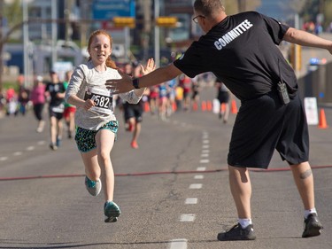 Izzy Smith high fives as she nears the 5 km finish line in the annual Sport Chek Mother's Day run at Chinook Centre on Sunday May 13, 2018. Smith finished second in the 5 km female under 14 category. The event is a fundraiser for the neonatal intensive care units in Calgary.