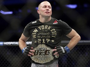 Georges St. Pierre reacts after winning the middleweight title against Michael Bisping at UFC 217 Sunday, Nov. 5, 2017, in QNew York. (AP Photo/Frank Franklin II)