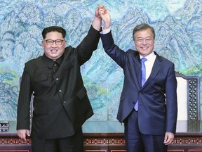 This April 27, 2018, file photo shows North Korean leader Kim Jong Un, left, and South Korean President Moon Jae-in raising their hands after signing a joint statement at the border village of Panmunjom in the Demilitarized Zone, South Korea.