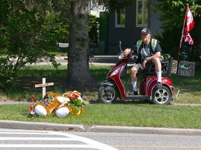 Andy Ethier stops to pay his respects at a roadside memorial on Acadia Drive S.E. on Wednesday, May 23, 2018, where two women were struck by a pickup truck at a crosswalk. 83-year-old Hilda Klemmer died at the scene, while her 21-year-old granddaughter remains in hospital.