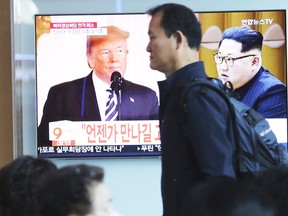 A man passes by a TV screen showing images of U.S. President Donald Trump, left, and North Korean leader Kim Jong Un during a news program at the Seoul Railway Station in Seoul, South Korea, Friday, May 25, 2018. (AP)