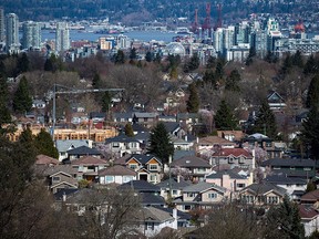 A condo building is seen under construction surrounded by houses in Vancouver on March 30, 2018.