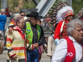 First Nations members take part in a procession across Reconciliation Bridge during the renaming ceremony for bridge, previously known as Langevin Bridge, in Calgary on Saturday May 26, 2018.
