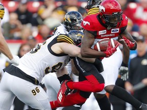 Calgary Stampeders DaVaris Daniels, right, is tackled by Hamilton Tiger-Cats Jason Neill during their game at McMahon Stadium in Calgary, on Saturday June 16, 2018.