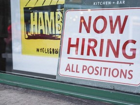 A Now Hiring sign in the window of a business on Wolf Street in Banff, Alta., on Monday, March 29, 2016.