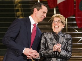 Former Ontario Premiere Dalton McGuinty laughs with Ontario Premier Kathleen Wynne before McGuinty's official portrait is unveiled at Queen's Park, in Toronto, Tuesday February 23, 2016.