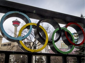 The Calgary Tower is seen with Olympic rings built into railing at Olympic Plaza in downtown Calgary, Alta., on Monday, March 20, 2017. The city is considering another Winter Olympics bid. Lyle Aspinall/Postmedia Network