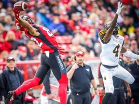 Calgary Stampeders Juwan Brescacin with outstanding catch in front of Richard Leonard of the Hamilton Tiger-Cats during CFL football in Calgary on Saturday, June 16, 2018.
