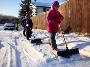 CALGARY.;  DECEMBER 25, 2015  -- Amina Farooq, 8, right, along with other members of the Islamic Association of North West Calgary, help shovel sidewalks during the the around the residential neighborhood along Ranchview Drive. Photo by Leah Hennel, Calgary Herald  For City story by Clara Ho