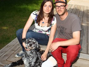 Rochelle and Jean-Michel Longval pose with their 15 month old Aussiedoodle dog Geo in southwest Calgary on Sunday, June 17, 2018. Geo was injured on Monday when trapped in a snare in the Bebo Grove area Fish Creek Park. Jim Wells/Postmedia