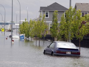 Cars sit parked in flood water in a restricted neighborhood in High River on July 4, 2013.