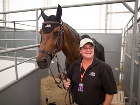 Farrier Heidi Mello stands with Tiffany Foster's horse Brighton in her work area at the Spruce Meadows National on Thursday June 7, 2018.