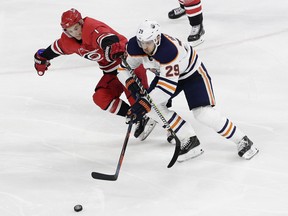 Carolina Hurricanes' Derek Ryan (7) and Edmonton Oilers' Leon Draisaitl (29), of Germany, chase the puck during the third period of an NHL hockey game in Raleigh, N.C., Tuesday, March 20, 2018. Edmonton won 7-3. (AP Photo/Gerry Broome) ORG XMIT: NCGB112