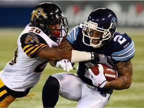 Chad Owens of the Toronto Argos is taken down by Emanuel Davis of the Hamilton Tigercats during CFL action at the Rogers Centre in Toronto, Ont. on October 4, 2013. Dave Abel/Toronto Sun/QMI Agency ORG XMIT: